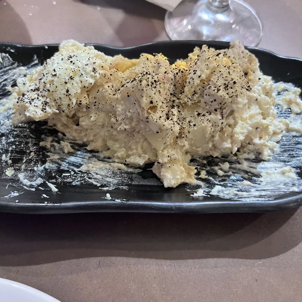Ensaladilla con pimienta negra en una fuente negra